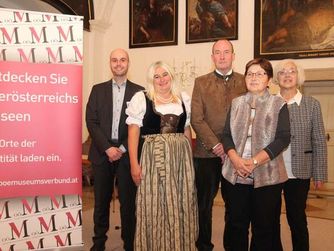 Vier Absolventinnen und Absolventen erhielten erstmals das Zertifikat "Museumskustode/-in plus" verliehen. Hier mit dem Geschäftsführer des Verbundes Oö. Museen Dr. Klaus Landa.