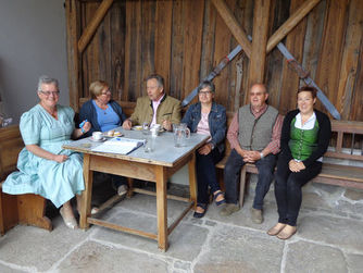 Museumsmitarbeiterinnen und -mitarbeiter mit Gästen im Sallabergerhaus in Zell an der Pram