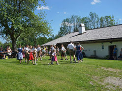 Gemütliche Stimmung im Schatten des Birnbaums mit Musik und einer Aufführung der Kindervolkstanzgruppe im Freilichtmuseum Unterkagererhof