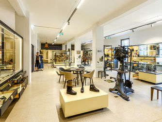  Bei einem Workshop können die jungen Teilnehmer/innen selbst handwerklich aktiv werden und in die Rolle eines Modellbauers schlüpfen. Foto: Blick in die Ausstellung.