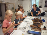 Kinder lernen beim Ferienspaß im Färbermuseum Gutau am 12. Juli 2025 das alte Handwerk des Blaudrucks kennen und fertigen gemeinsam ein Utensilo an. Mit Anmeldung über die Ferienpassaktion der Gemeinde Gutau!